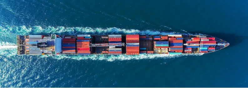 Container ship at sea carrying stacked ISO containers.